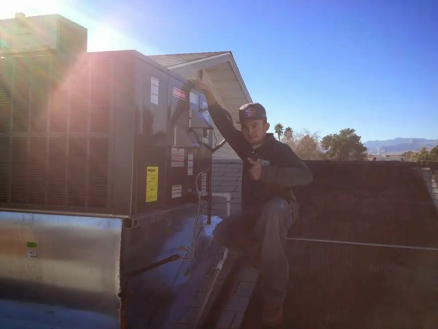 HVAC technician performing Air Duct Cleaning on a rooftop unit in Westerville