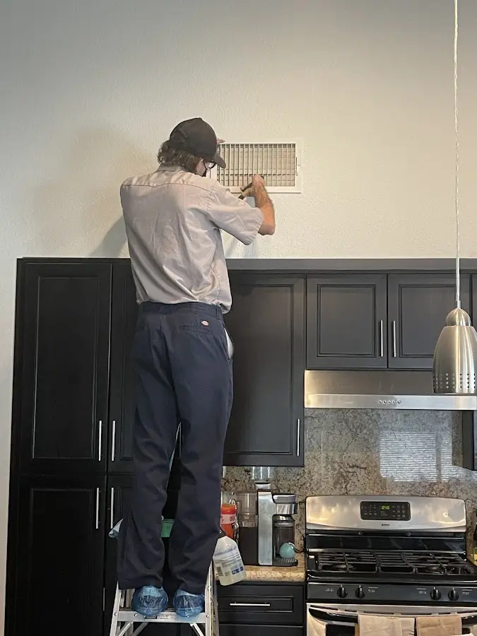Technician inspecting an air vent during HVAC service in Westerville